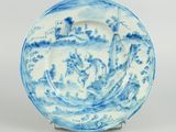 blue and white porcelain plate with a landscape scene on it