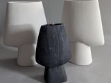 two white and black vases sitting next to each other on a table