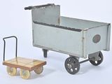 un petit chariot jouet surmonté d'une remorque en bois
