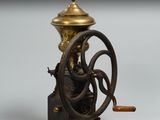 un moulin à café à l'ancienne, avec un socle en bois et un couvercle en laiton