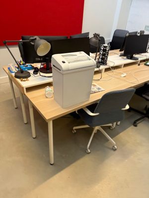 un bureau sur lequel se trouvent deux ordinateurs et une imprimante