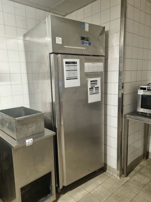 a refrigerator and a microwave in a small kitchen