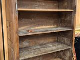 an old wooden bookcase with shelves in a room