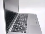 a silver laptop with a black keyboard on a white surface