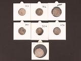 several different types of coins are displayed on a black surface