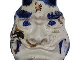 a blue and white ceramic mask with a cat ' s head