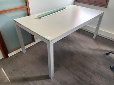 a white desk with a green roll of tape on it