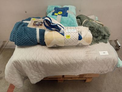 un tas de couvertures posé sur un lit dans une chambre