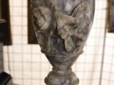 a marble vase on a table with a mirror in the background
