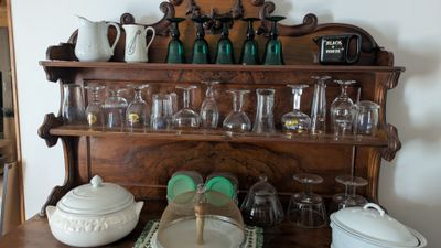 une étagère en bois sur laquelle sont posés plusieurs objets en verre