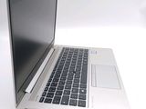 a silver laptop with a black keyboard on a white surface