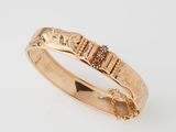 a close up of a gold ring with diamonds on a white background