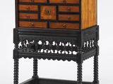 une commode en bois noir et marron à tiroirs, montée sur roulettes