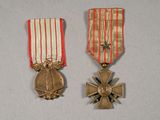 deux médailles et une croix sur un fond blanc