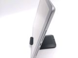 a tablet computer sitting on a stand on a white surface