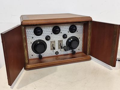 une radio à l'ancienne posée sur une table, ses volets ouverts