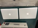 deux ordinateurs portables Apple posés l'un à côté de l'autre sur une table