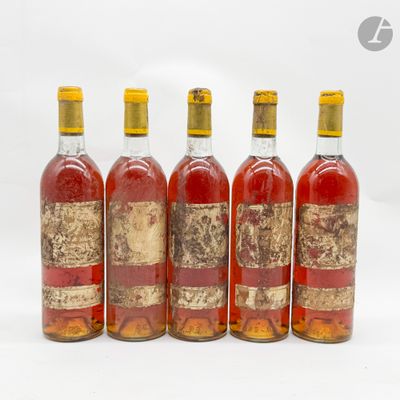 quatre bouteilles de vin sont alignées sur une surface blanche
