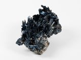 un petit morceau de cristaux noirs sur une surface blanche