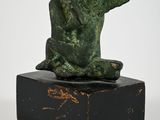 statue of a man sitting on top of a black marble block