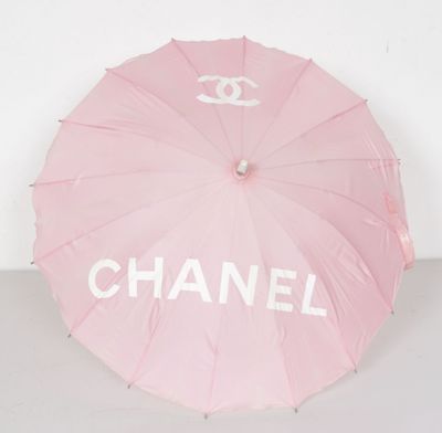 chanel logo umbrella in pink with white letters and a chanel logo on it