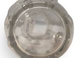 a close up of a silver object on a white surface