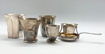 cinq tasses et cuillères en argent posées sur une table