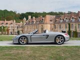 a silver sports car parked in front of a large building