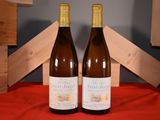 two bottles of wine sitting next to each other on a table