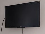 une télévision à écran plat fixée au mur au-dessus d'un bureau