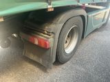a green semi truck parked on the side of the road