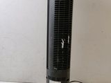an electric fan sitting on top of a table next to a white wall