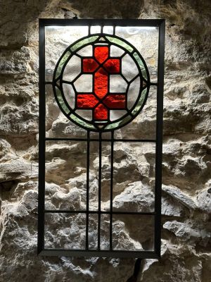 un vitrail orné d'une croix rouge
