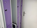 purple lockers in a room with a white door and a black chair