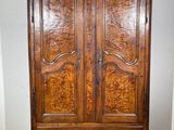 an image of a wooden armoire in a room with tile flooring