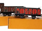 two toy trains sitting on top of boxes on a white surface