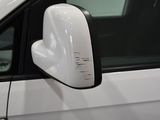 a side view mirror of a white car with a black trim