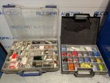 two boxes of assorted electrical components sitting on a table