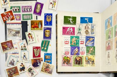 un livre ouvert sur lequel sont collés des timbres et dont les pages sont couvertes de timbres