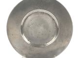 a silver plate on a stand on a white surface