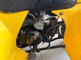 a close up of a yellow motorcycle parked in a garage