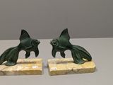 une paire de serre-livres en bronze représentant des poissons, sur des socles en marbre