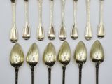 eight silverplated spoons and six silverplated spoons on a white surface