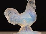 a glass figurine of a rooster on a table