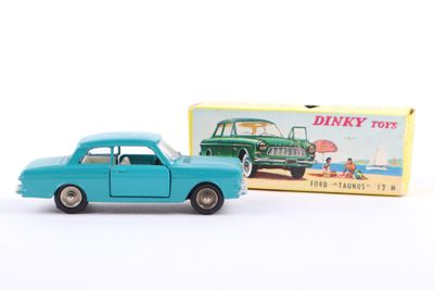 toy car in front of a boxed box of dinky toys on a white surface