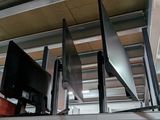 three televisions that are on a shelf in a room