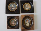 Quatre portraits miniatures encadrés représentant des femmes et des enfants sont accrochés au mur