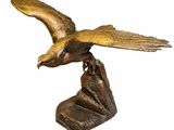 une image représentant une statue en bronze d'un oiseau posé sur un rocher