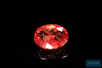 un losange rouge sur une surface noire, avec un fond noir