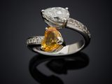 an engagement ring with a pear shaped diamond and a pear shaped yellow sapphire